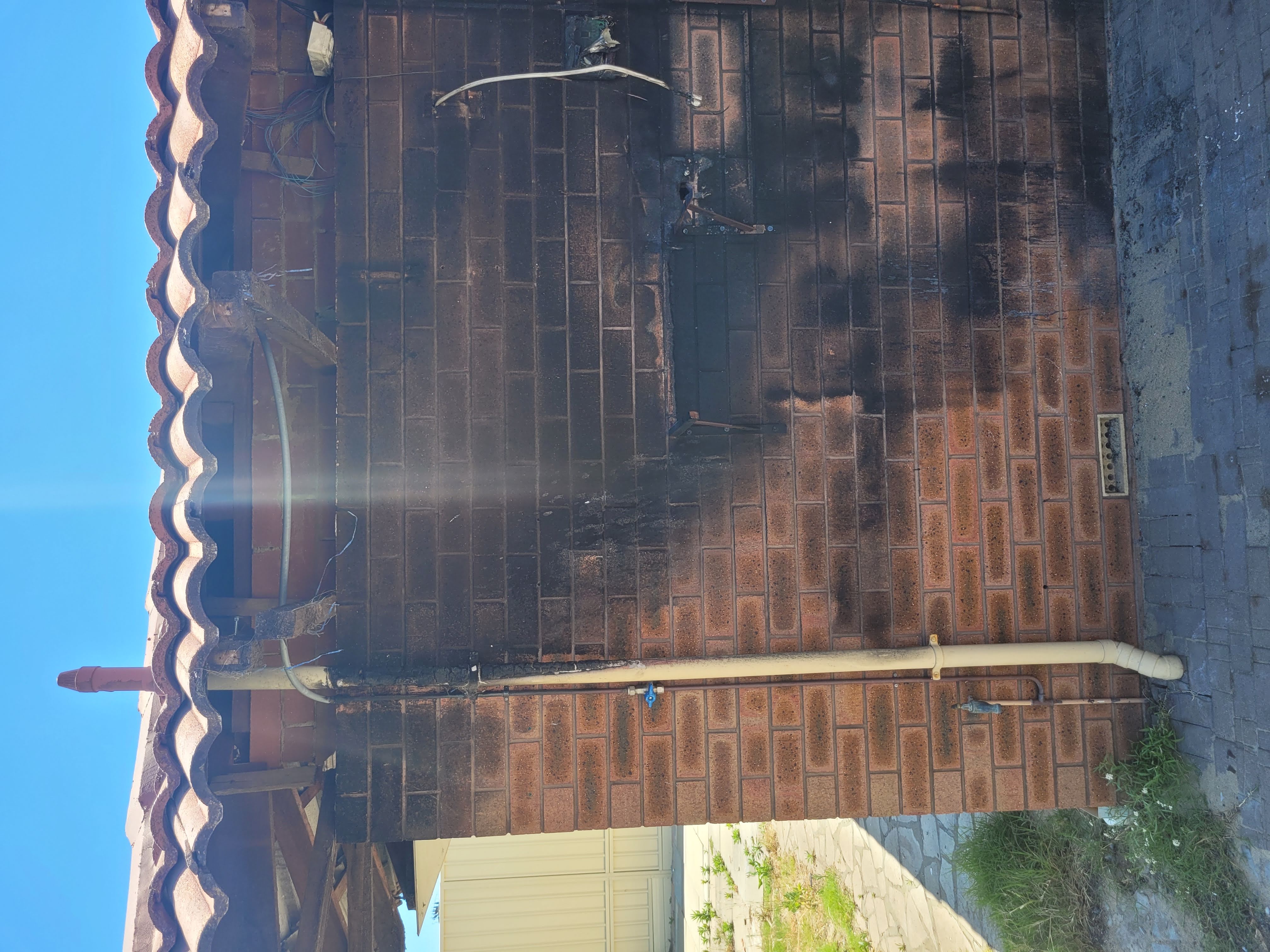 Brick exterior wall covered in heavy soot from fire damage